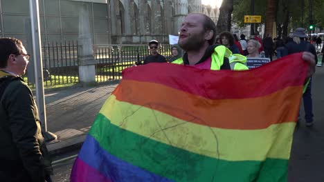 Antifa-protester-holding-a-flag-screams-at-Brexit-supporters,-Parliament-Square,-London,-UK