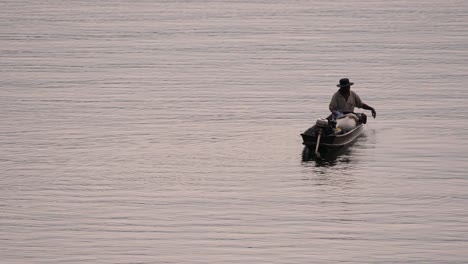 Fisherman-silhouetting-as-he-is-casting-and-drawing-his-net-in-the-River-before-dark