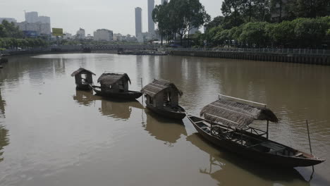 Luftaufnahme-Einer-Reihe-Alter-Flussfischerboote-Im-Traditionellen-Stil-In-Einem-Hoang-Sa-Kanal-Im-Bezirk-Binh-Thanh-In-Ho-Chi-Minh-Stadt-Oder-Saigon,-Vietnam