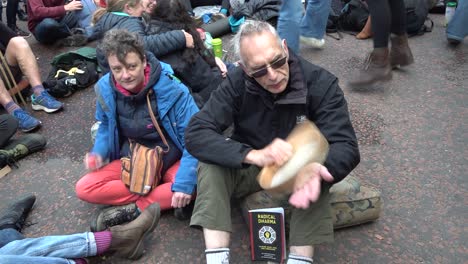 Una-Pareja-De-Ancianos-Toca-Música-Durante-Las-Protestas-De-La-Rebelión-De-Extinción-En-Londres,-Reino-Unido.