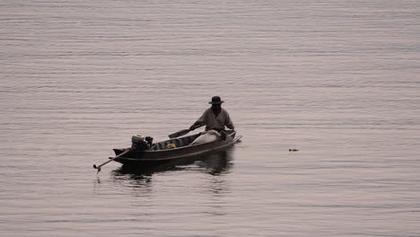 Pescador-Perfilando-Mientras-Lanza-Y-Saca-Su-Red-En-El-Río-Antes-Del-Anochecer,-En-Cámara-Lenta