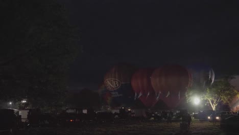 Festival-De-Globos-Aerostáticos-Por-La-Noche-Disparando-Propano-Creando-Un-Resplandor-Nocturno-En-Una-Noche-De-Verano