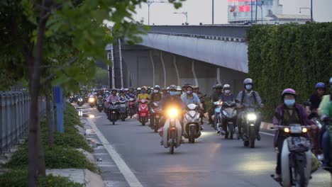 Tráfico-En-Vietnam-Con-Muchas-Motos-Y-Algunos-árboles-Junto-A-Un-Puente.