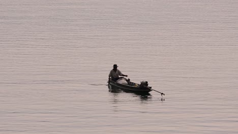 Pescador-Perfilando-Mientras-Lanza-Y-Saca-Su-Red-En-El-Río-Antes-Del-Anochecer,-En-Cámara-Lenta