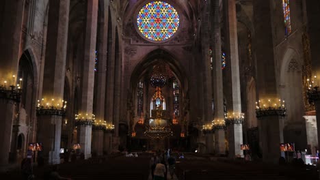 Beautiful-Cinematic-Shot-of-Inside-of-Cathedral-Sanctuary-With-Cadle-Lit-Pillars-and-Stained-Glass-Window