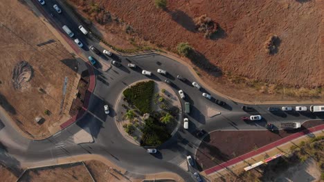 Birds-eye-view-of-a-roundabout-with-traffic-and-orange-green-foliage-surrounding