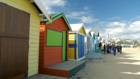 Tourists-walking-and-taking-photo-at-Brighton-Bathing-Boxes,-Melbourne,-Australia