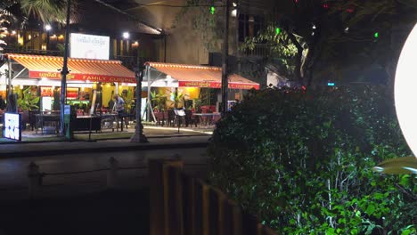 Amplia-Toma-Deslizante-De-Un-Restaurante-Junto-Al-Río-Por-La-Noche