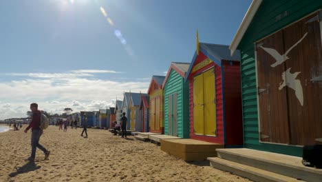 Tourists-walking-and-taking-photo-at-Brighton-Bathing-Boxes,-Melbourne,-Australia