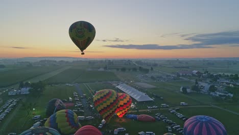 Luftaufnahme-Von-Heißluftballons,-Die-Sich-An-Einem-Sommermorgen-Bei-Einem-Heißluftballonfestival-Füllen-Und-Abheben