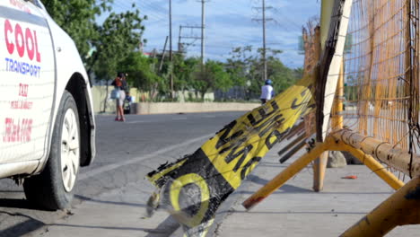 Parking-cab,-taxi-on-the-side-of-the-road-as-a-ripped-off-poster-is-waving-in-the-wind