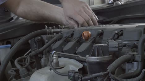 Toma-Fija-De-Las-Manos-De-Un-Mecánico-Mientras-Trabaja-En-El-Motor-De-Un-Automóvil.