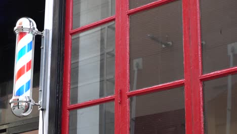 Un-Poste-De-Barbería-Cerca-De-Una-Ventana-Roja