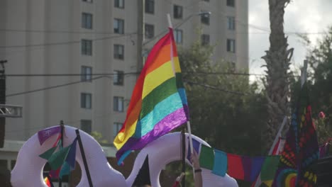 Slow-Motion-Shot-of-Pride-Flag-Waving-in-Air-at-River-City-Pride-Parade-in-Jacksonville,-FL