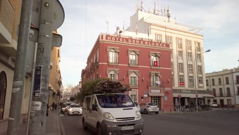 Van-Transporting-Christmas-Trees-on-Roof-in-Spain,-Slowmo-Tracking-Pan