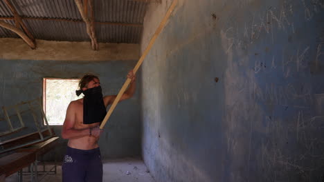 Charity-event-member-cleaning-and-removing-dust-from-classroom's-wall-before-painting