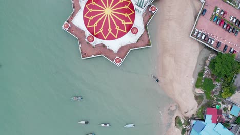 La-Mezquita-Flotante-Tanjung-Bunga-Se-Ve-Desde-Arriba-Con-Una-Enorme-Cúpula-Roja-Y-Amarilla,-Un-Drone-Aéreo-Desde-Arriba