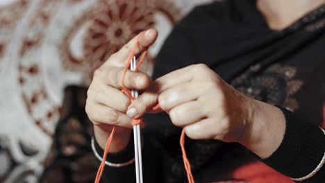 Woman-starting-first-row-of-knitting-with-red-wool-and-two-needle-crafts