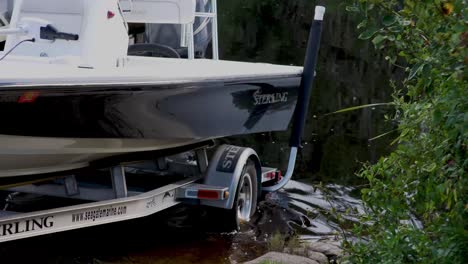 Truck-launches-boat-and-trailer-into-the-water-with-dock-in-the-background