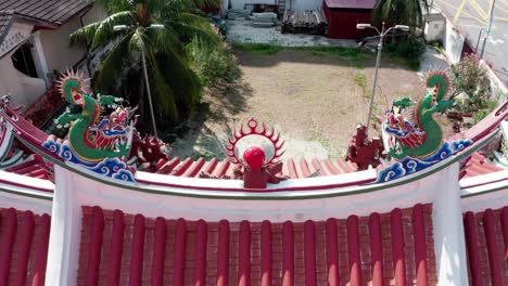 Chinese-dragon-sculptures-on-the-roof-of-the-Yeoh-Kongsi-Clan-Temple,-Aerial-drone-lift-shot