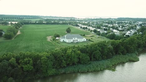 Casa-De-Lujo-Detrás-Del-Bosque-En-La-Costa-De-La-Isla-De-Kent,-La-Bahía-De-Chesapeake,-Maryland,-EE.UU.,-Vista-Aérea-Cinematográfica