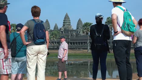 Medium-Exterior-Timelapse-Shot-of-Tourists-Taking-Photos-Outside-Angkor-Wat-on-the-Horizon
