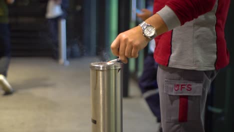 June-2019,-Istanbul,-Turkey:-a-man-dropping-some-ash-on-an-ash-tray-column-of-a-smoking-room-in-Istanbul-airport