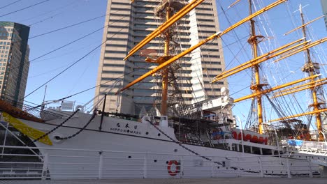 Persona-Con-Mochila-Caminando-Frente-Al-Barco-Nippon-Maru-En-El-Puerto-De-Yokohama-En-Japón---Edificio-Alto---Tiro-De-ángulo-Bajo