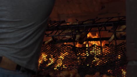 Hombre-Saca-Pollo-De-Una-Gran-Parrilla-Asadora