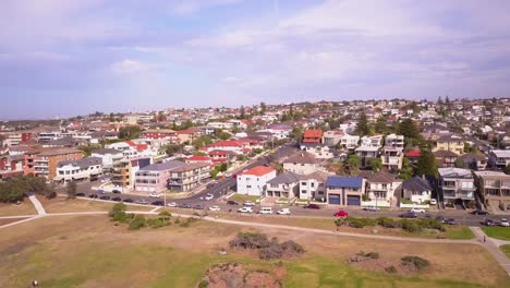 Flying-over-beach-front-properties-in-a-countryside-with-green-grass-front-yard