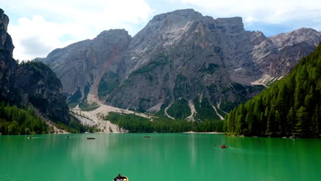 Pragser-Wildsee,-Auch-Bekannt-Als-Pragser-Wildsee,-Mit-Paddelbootfahrern,-Die-Den-Tag-Genießen,-Aufsteigende-Luftaufnahme