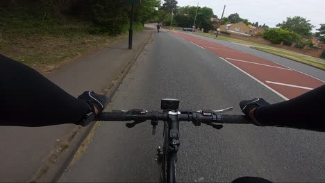 Vista-POV-De-Ciclistas-Que-Pasan-Por-Un-Dispositivo-Indicador-De-Velocidad-En-Northwood,-Londres