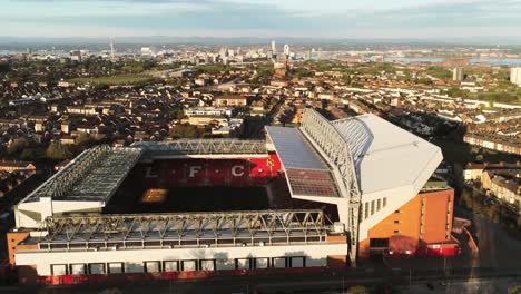 Das-Ikonische-Stadiongelände-Des-Anfield-Fußballstadions-Von-Liverpool-Bei-Sonnenaufgang,-Luftaufnahme