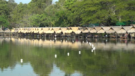 Hermoso-Lago-Huay-Tung-Tao-En-Chiang-Mai,-Fondo-De-Bosque-Exuberante,-Mostrando-Las-Cabañas-De-Paja-En-La-Orilla-Del-Lago