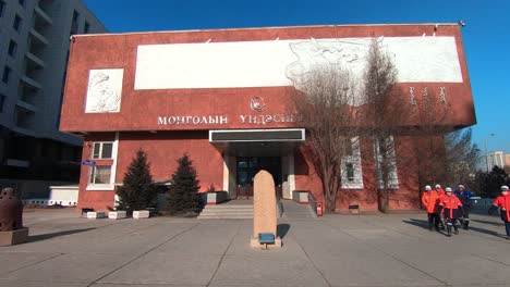 Construction-Workers-Walk-Past-The-National-Museum-Of-Mongolia-In-Ulaanbaatar