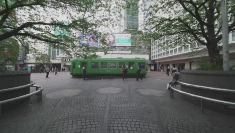 Der-Berühmte-Grüne-Bus-Neben-Dem-Bahnhof-Shibuya-In-Tokio,-Japan,-Unter-Weltweiter-Sperrung,-Ohne-Touristen-Und-Nur-Wenige-Menschen,-Die-Während-Der-Covid-19-Pandemie-Herumlaufen-–-Totalaufnahme