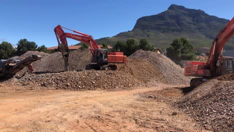 Amplia-Toma-De-Excavadoras-Hitachi-Zaxis-Trabajando-En-Un-Sitio-De-Construcción-En-Ciudad-Del-Cabo,-Sudáfrica