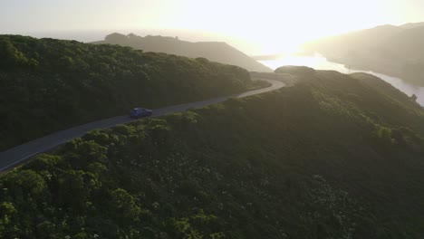 Blue-Porsche-Macan-at-sunset-driving-on-a-coastal-highway-in-the-Marin-Headlands-of-San-Fransisco,-USA