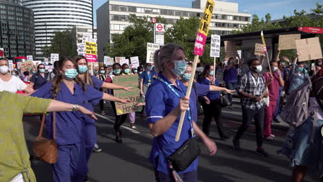 Los-Manifestantes-En-La-Marcha-Por-La-Justicia-Pagada-Por-El-Servicio-Nacional-De-Salud-Practican-El-Distanciamiento-Social-Extendiendo-Los-Brazos