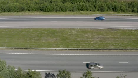 Top-down-aerial-view-of-cars-passing-quickly-on-a-motorway-in-Finland-near-Kerava