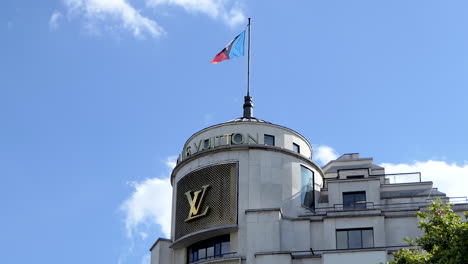 Louis-Vuitton-Flagge-Weht-Im-Wind-Auf-Dem-Dach-Des-Pariser-Boutique-Ladens-Auf-Den-Champs-Élysées,-Paris,-Frankreich