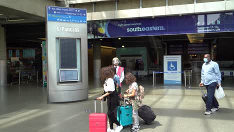 Hombre-Vestido-Con-Equipo-De-Protección-Dirige-A-Los-Miembros-Del-Público-En-Kings-Cross-St-Pancras,-Londres,-Reino-Unido.