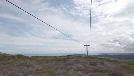 Passing-colourful-cable-car-gondola-tourism-sightseeing-transportation-travelling-across-scenic-mountain-valley-hillside