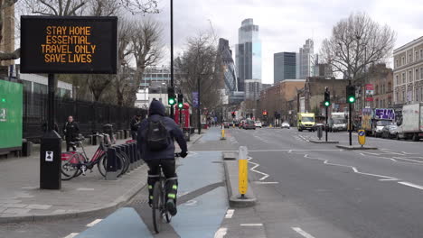 An-ambulance-passes-a-road-sign-on-Whitechapel-Road-in-East-London-that-says-“Stay-home,-essential-travel-only,-save-lives”-during-the-Coronavirus-outbreak