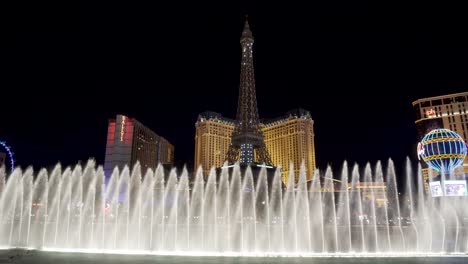 Fuente-Bellagio-Y-Paris-Hotel-And-Casino,-Las-Vegas-Por-La-Noche,-Nevada,-EE.UU.