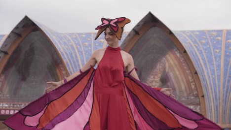 A-beautiful-woman-in-costume-as-a-butterfly-welcoming-festivalgoers-outside-the-gates-of-the-festival-Tomorrowland,-Boom-Belgium