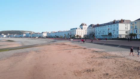 People-walking-along-Llandudno-beach-in-the-late-afternoon,-Wales