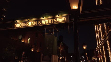 Night-time-establishing-shot-of-Gooderham-and-Worts-sign,-with-flickering-gas-lamp