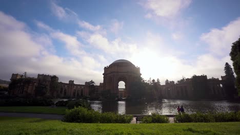 El-Palacio-De-Bellas-Artes,-Las-Nubes-Moviéndose-Rápido-Y-La-Gente-Caminando-Junto-Al-Lago