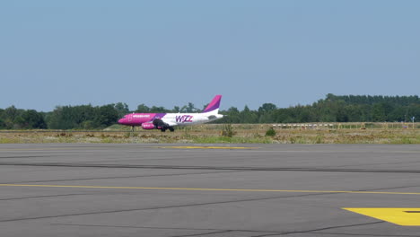 Wizzair-Airbus-Flugzeug-Verlässt-Die-Landebahn,-Sonniger-Tag